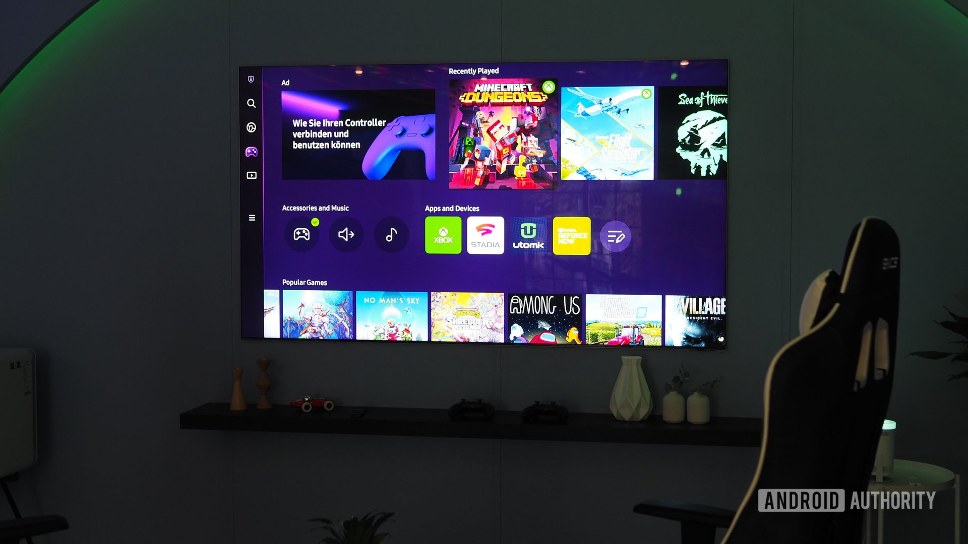 The Samsung Gaming Hub on a TV with a gaming chair in front of it in a darkened room.