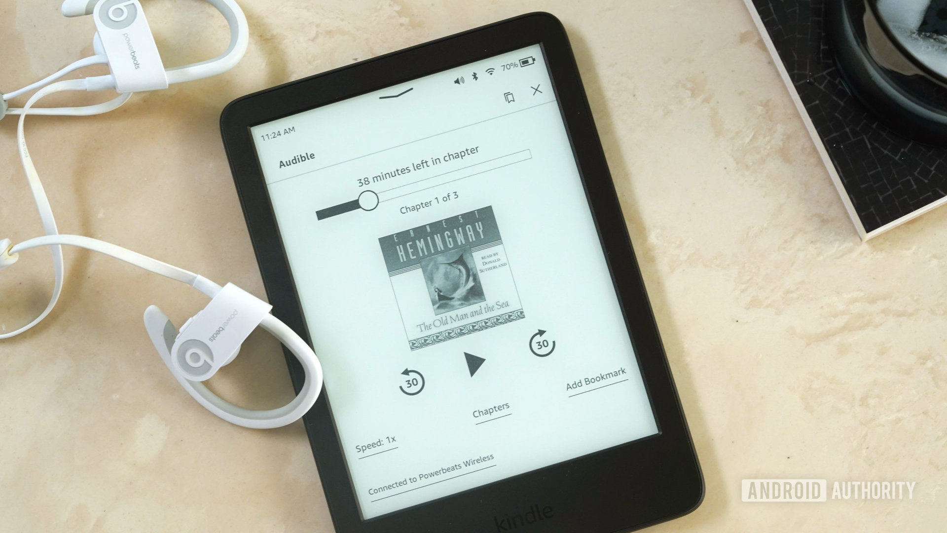 Un Amazon Kindle 2022 descansa sobre una superficie de mármol que muestra un audiolibro.