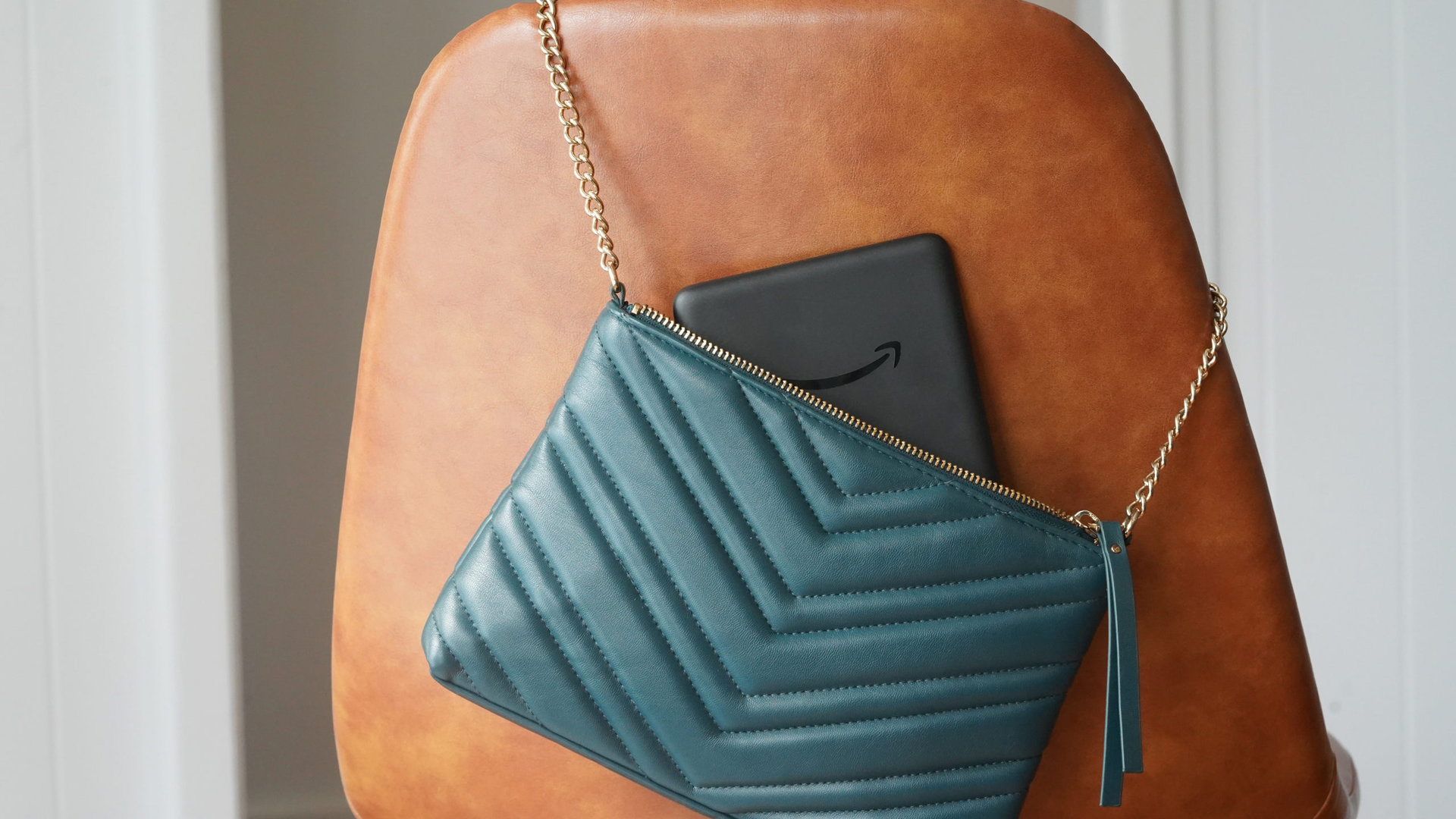 An Amazon Kindle sticks out of a woman's purse.
