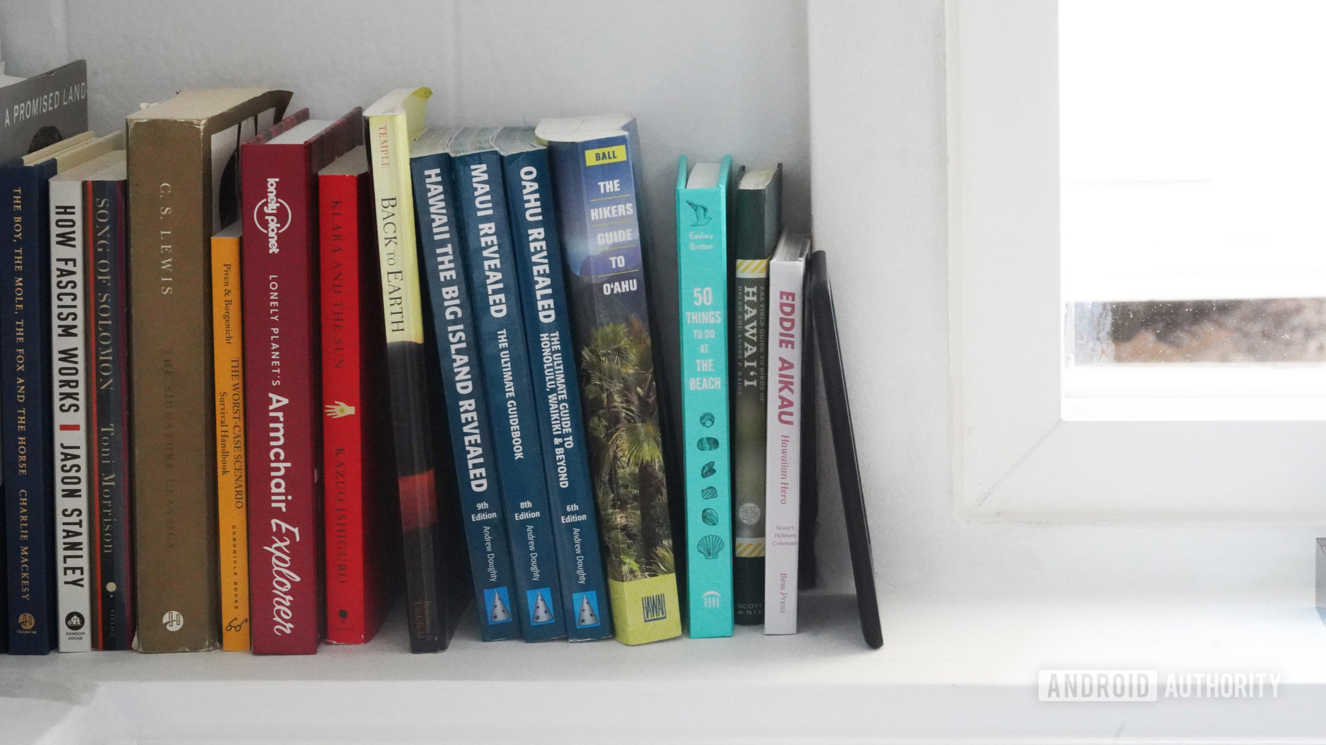 An Amazon Kindle 2022 blends in among books on an owners bookshelf.