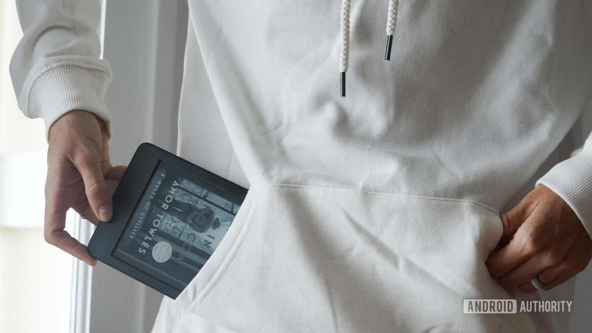 Un usuario saca un Amazon Kindle 2022 del bolsillo de su sudadera.