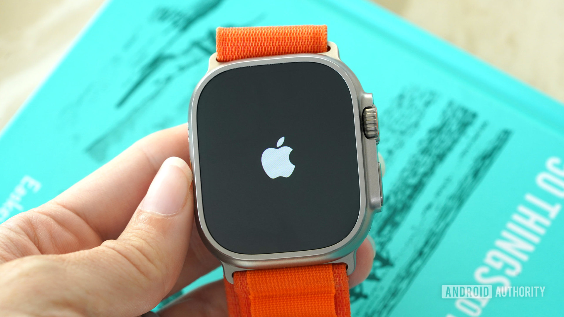 Apple Watch Ultra di tangan pengguna menampilkan logo Apple.