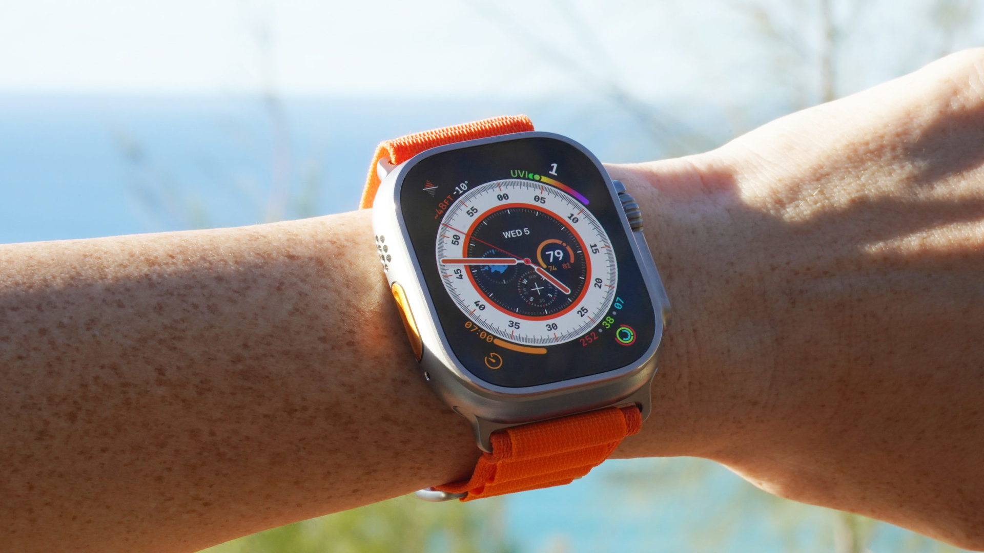 An Apple Watch Ultra on a user's wrist displays the Wayfinder watch face.