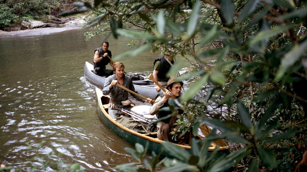 Four men in two canoes approach the shore of a river in Deliverance - best action thrillers on Netflix