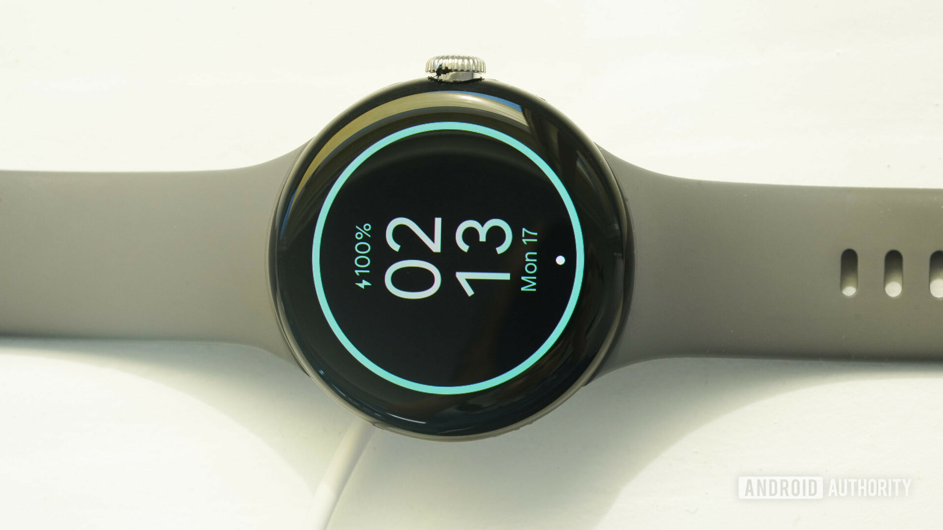 A Google Pixel Watch charges on a white surface