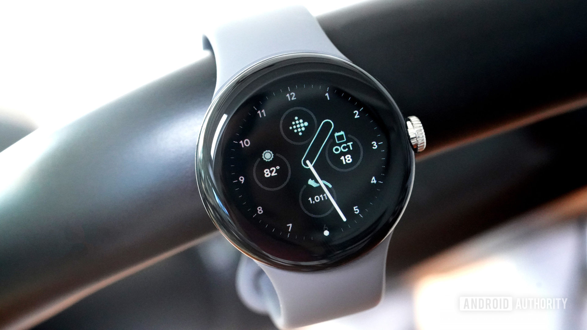 Google Pixel Watch tergantung dari sepeda stasioner yang menampilkan tampilan jam Klasik.