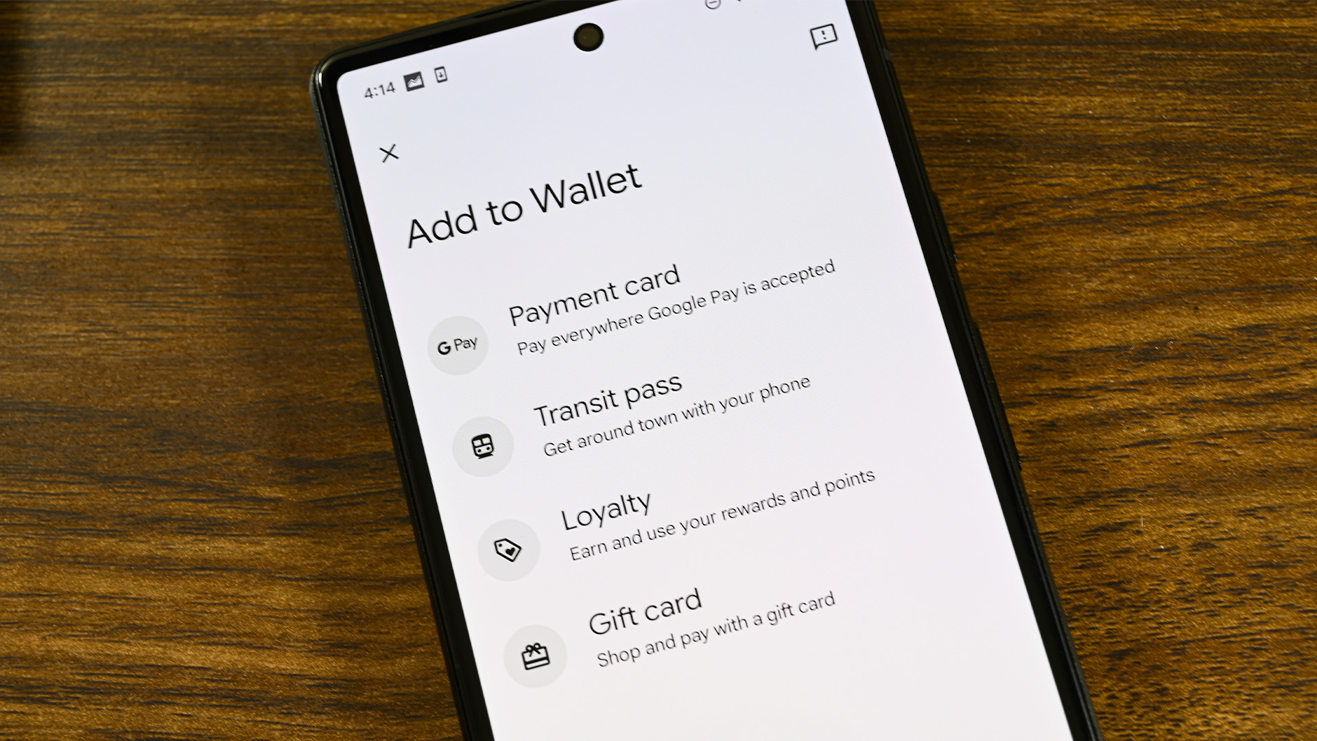 A photo of a smartphone showing the Google Wallet app's &quot;Add to Wallet&quot; screen showing various payment methods.