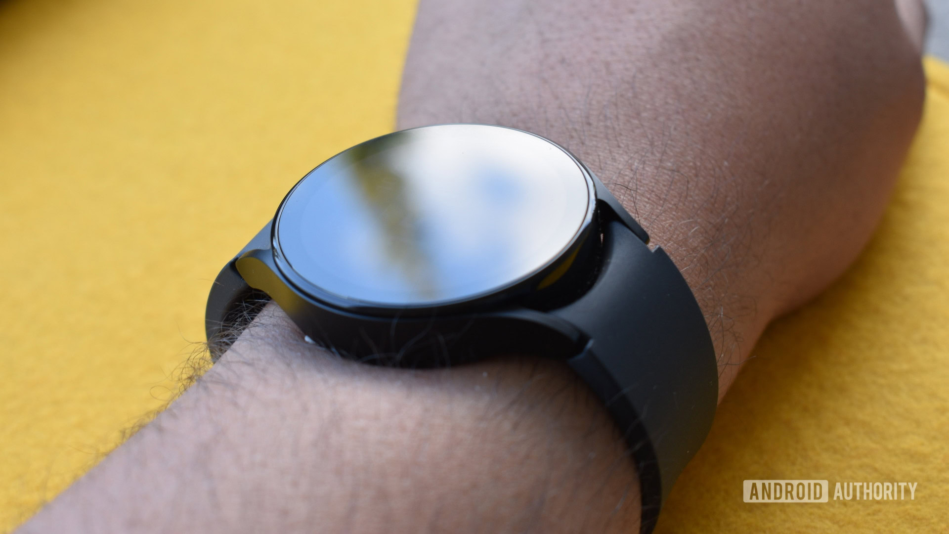 A Samsung Galaxy Watch 5 on a user's wrist displays a blank screen. 