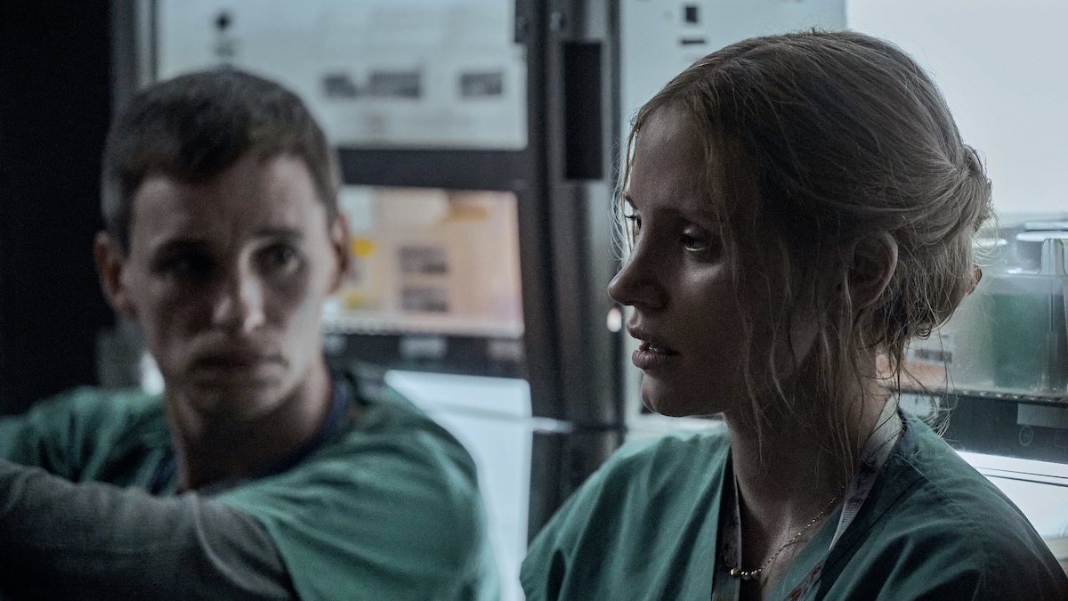 Dua perawat, Eddie Redmayne sebagai Charlie Cullen dan Jessica Chastain sebagai Amy Loughren, film misteri di netflix duduk di lantai bersama di The Good Nurse