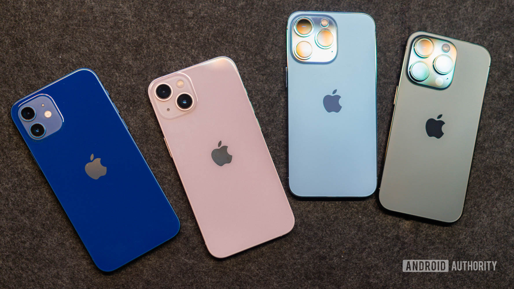 黒いマットの上に置いたiPhone 12、iPhone 13、iPhone 14、iPhone 14の背面を上から見たところ。