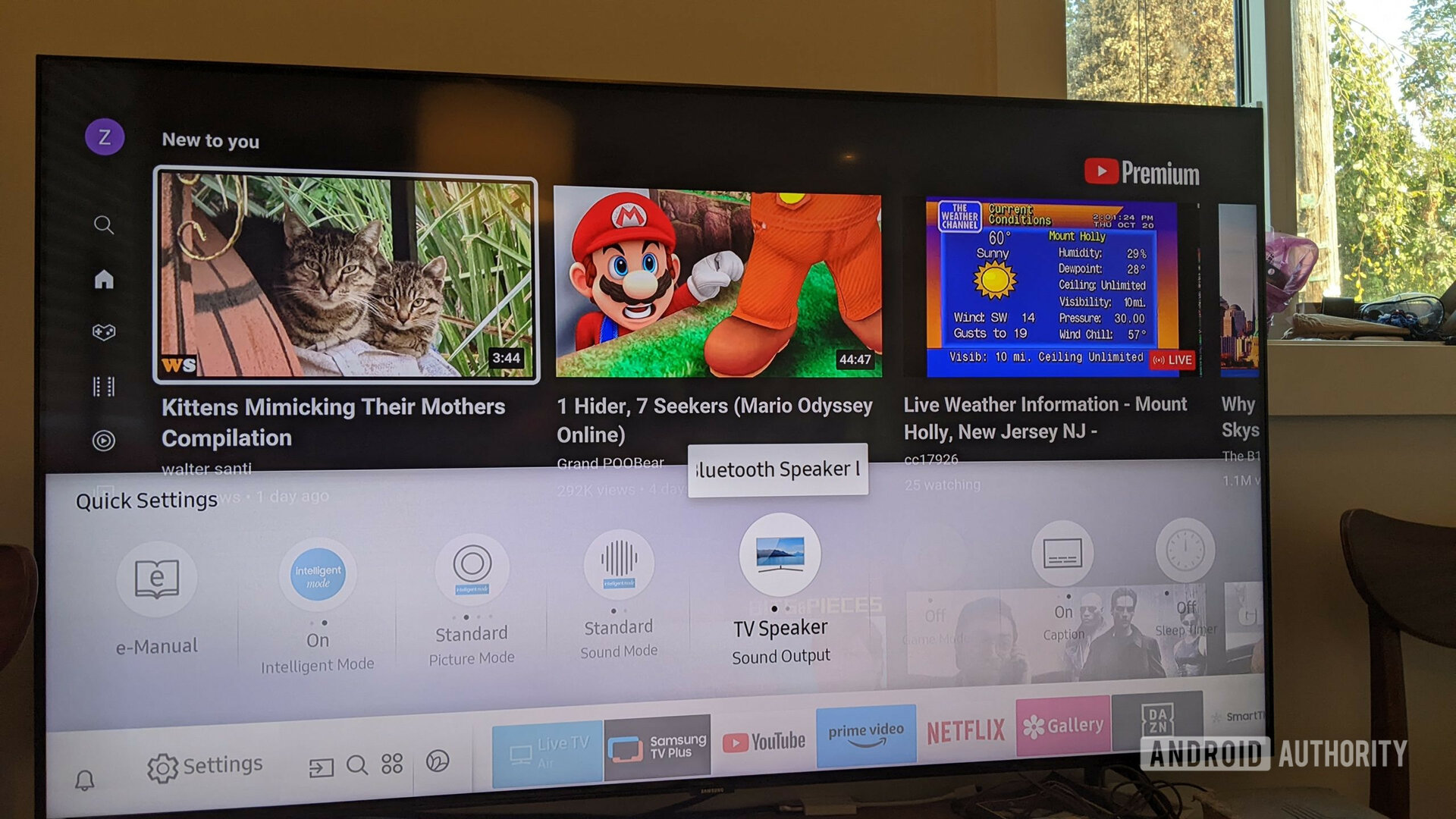 A photograph of a Samsung TV showing the settings menu with the Bluetooth speaker option selected.