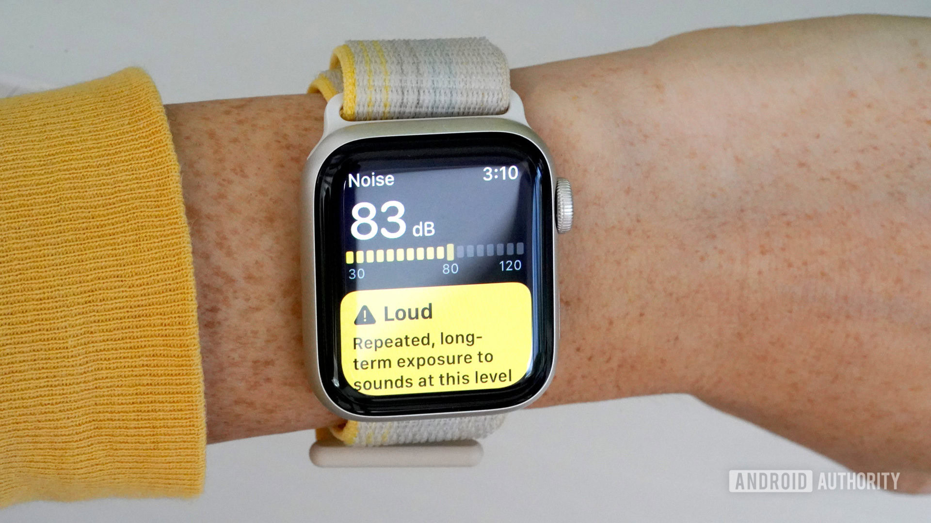 Apple Watch SE 2 on a user's wrist displays the Noise app measuring 83dB of environment noise.