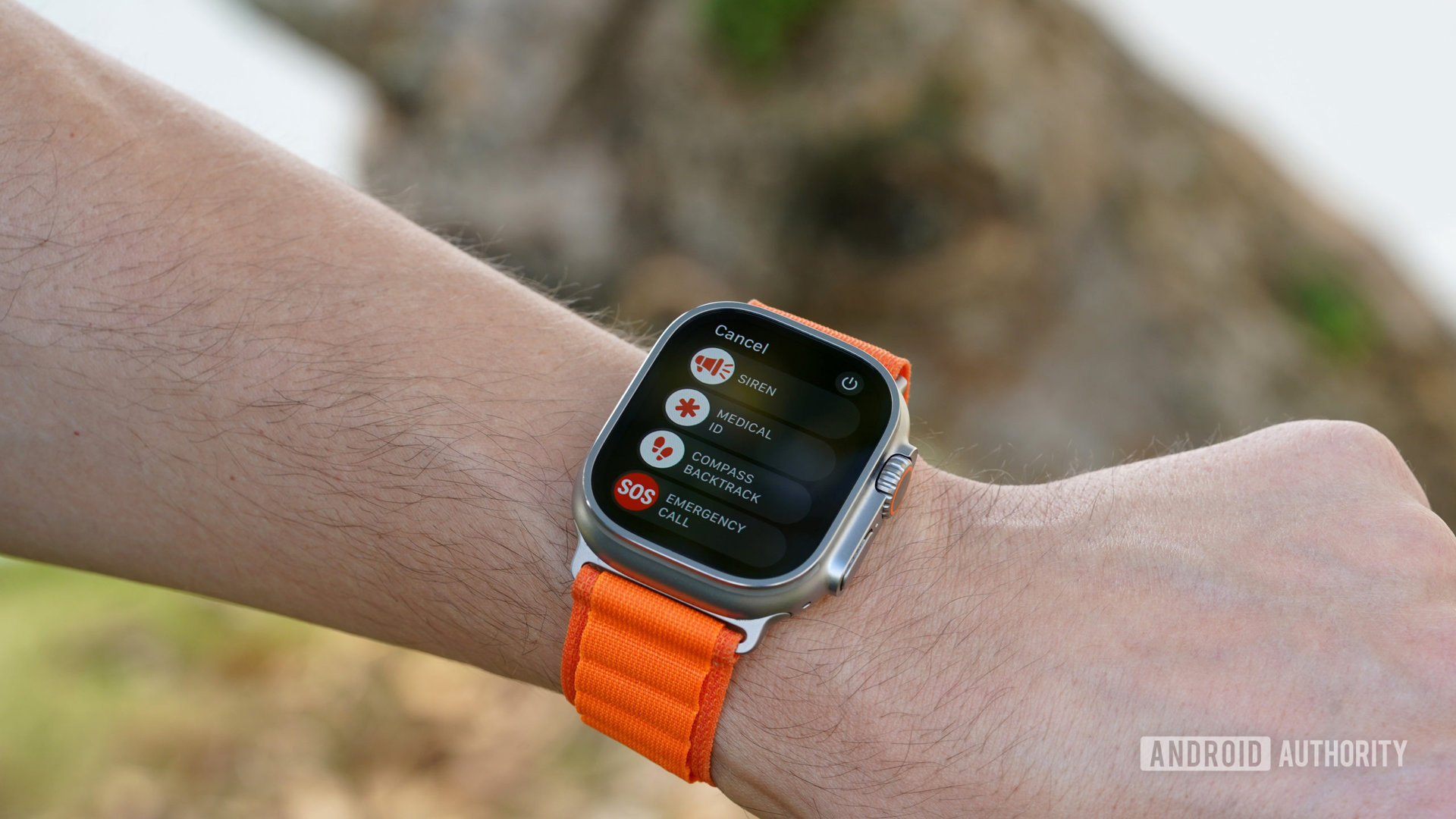 Apple Watch Ultra di pergelangan tangan pengguna menampilkan menu fitur keselamatan termasuk Sirene.