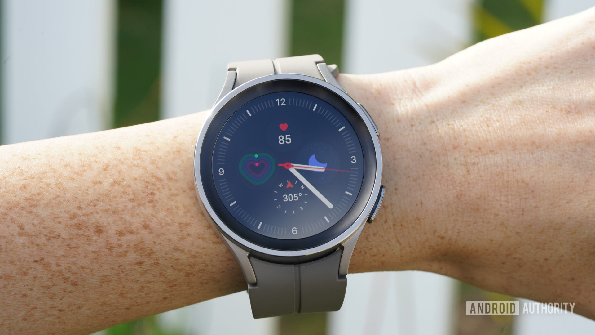 Galaxy Watch 5 Pro di pergelangan tangan pengguna menampilkan tampilan jam.