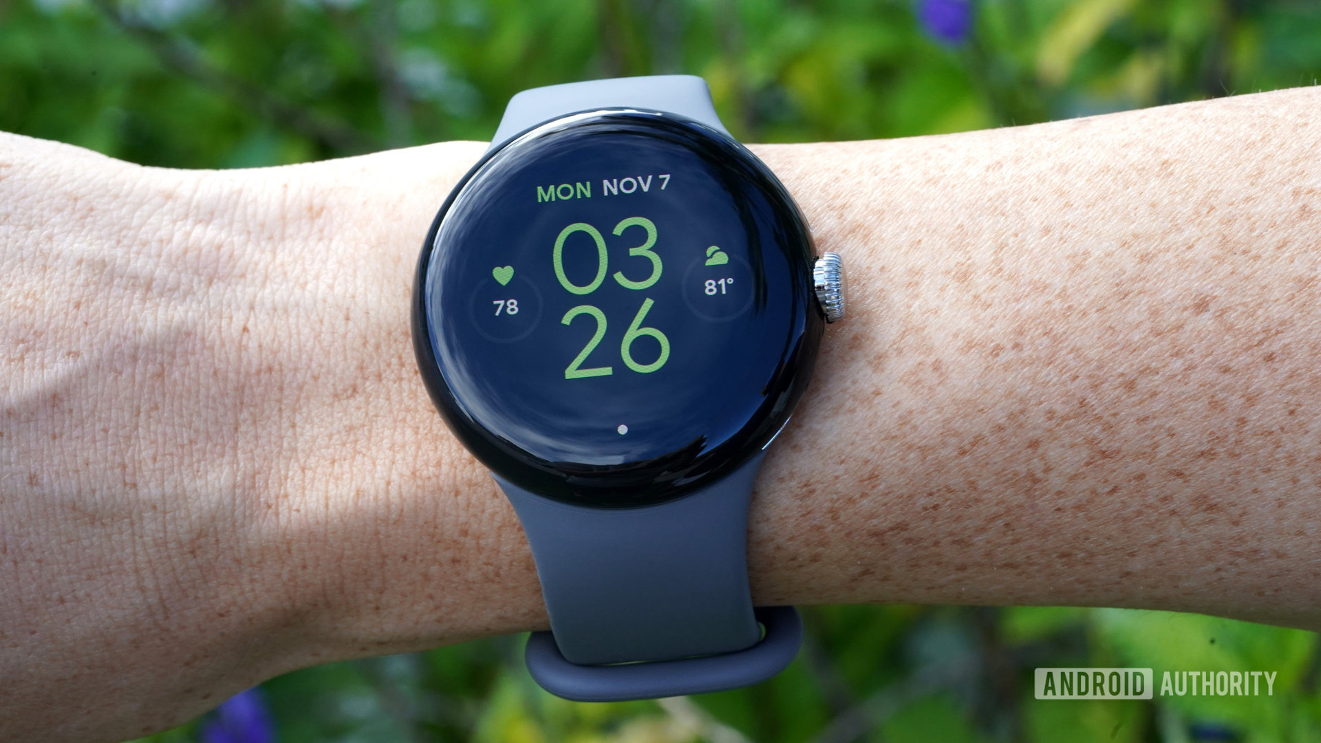 Google Pixel Watch di pergelangan tangan pengguna menampilkan tampilan jam.