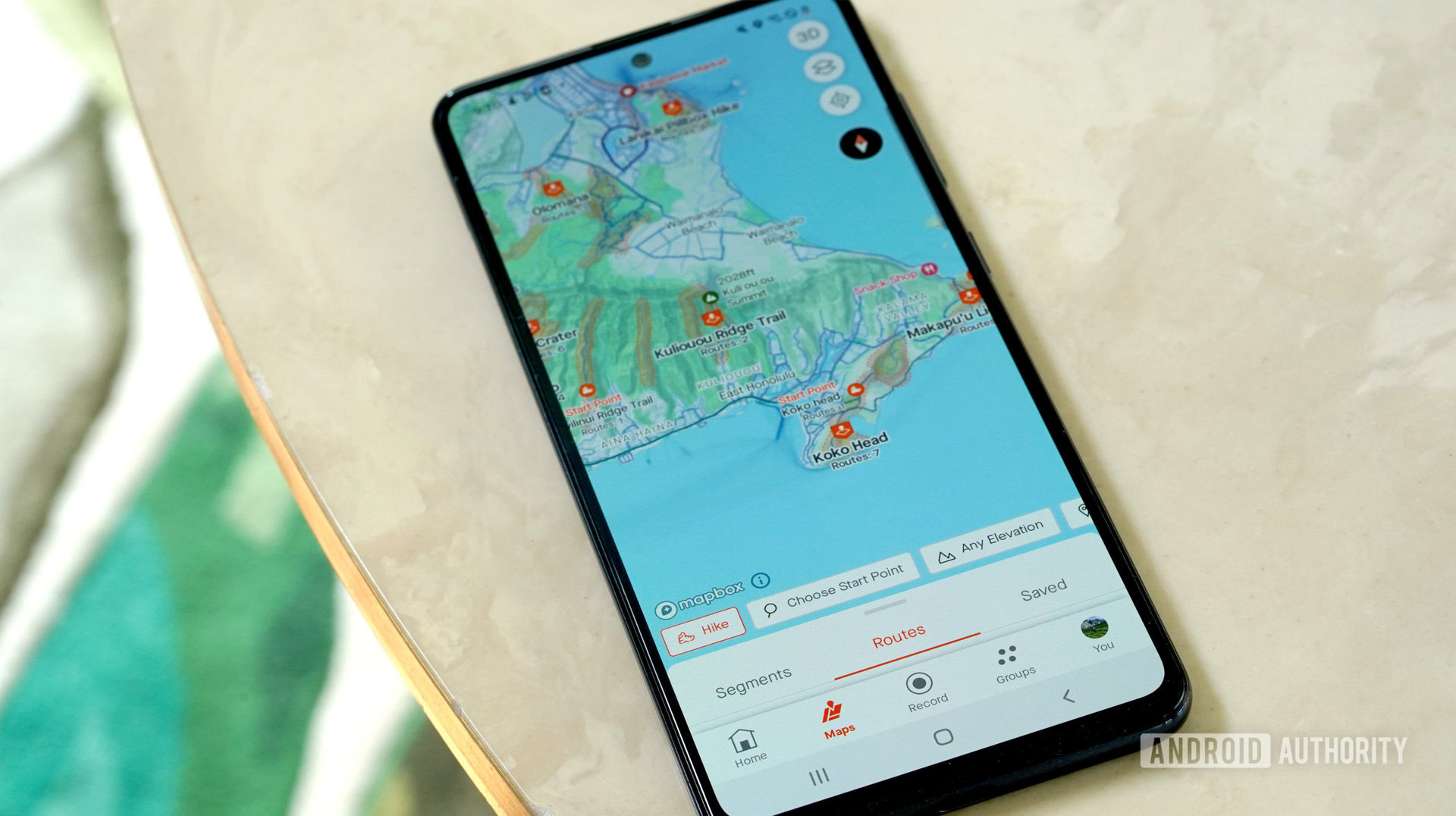 Galaxy A51 rests on a marble table showing the user's Strava Maps tab.