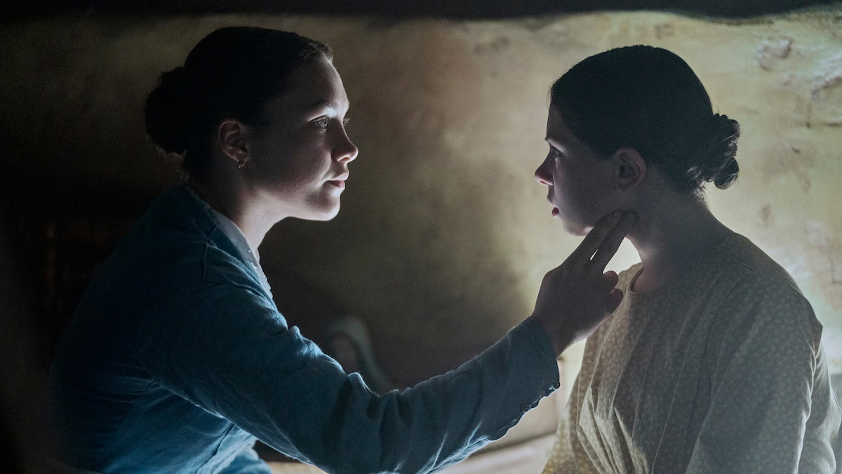 Florence Pugh as Lib Wright reaching her hand out to Kíla Lord Cassidy as Anna O’Donnell in The Wonder