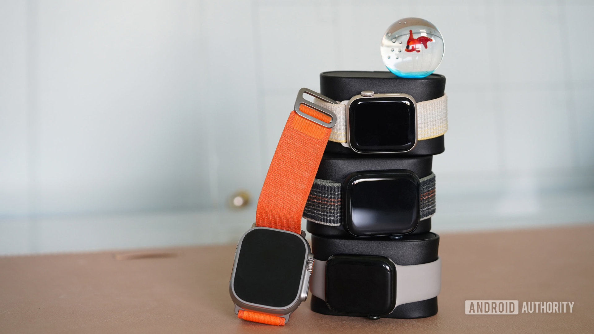 A stack of Apple Watches includes a Series 7, Series 8, SE 2022, and Ultra model