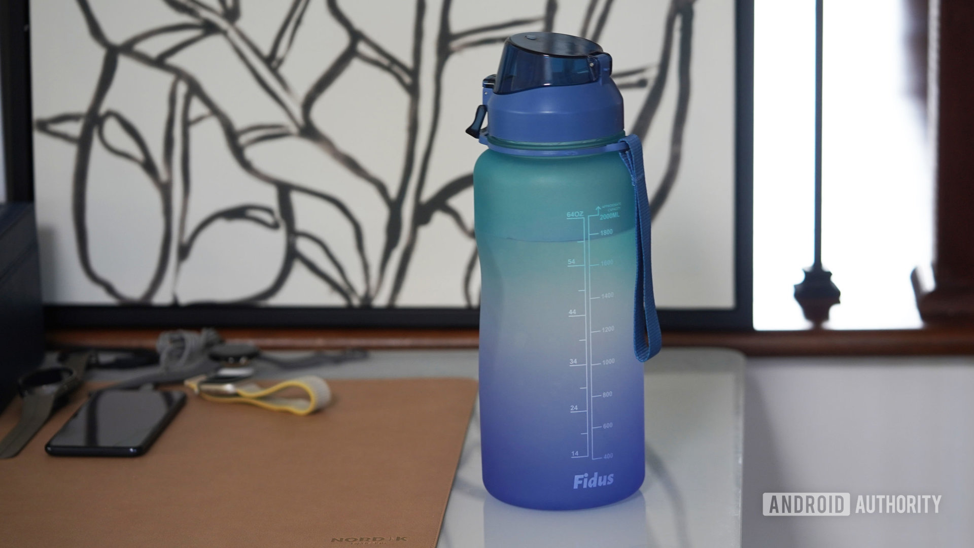 Botol air besar terletak di meja penulis teknologi. 
