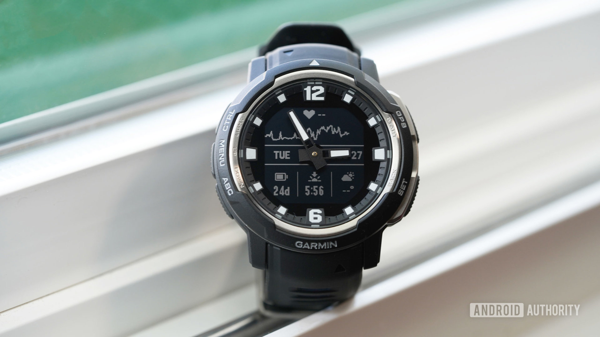 A Garmin Instinct Crossover displays a basic watch face.