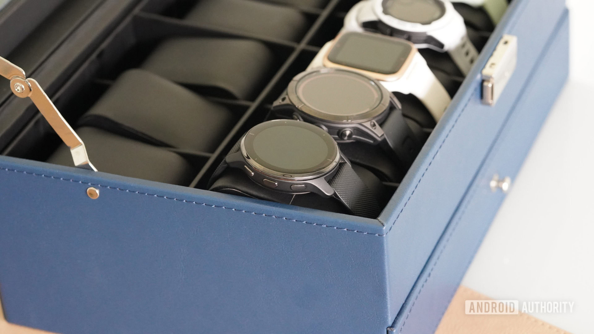 An open watch box displays a variety of Garmin wearables including a Venu 2 Plus.