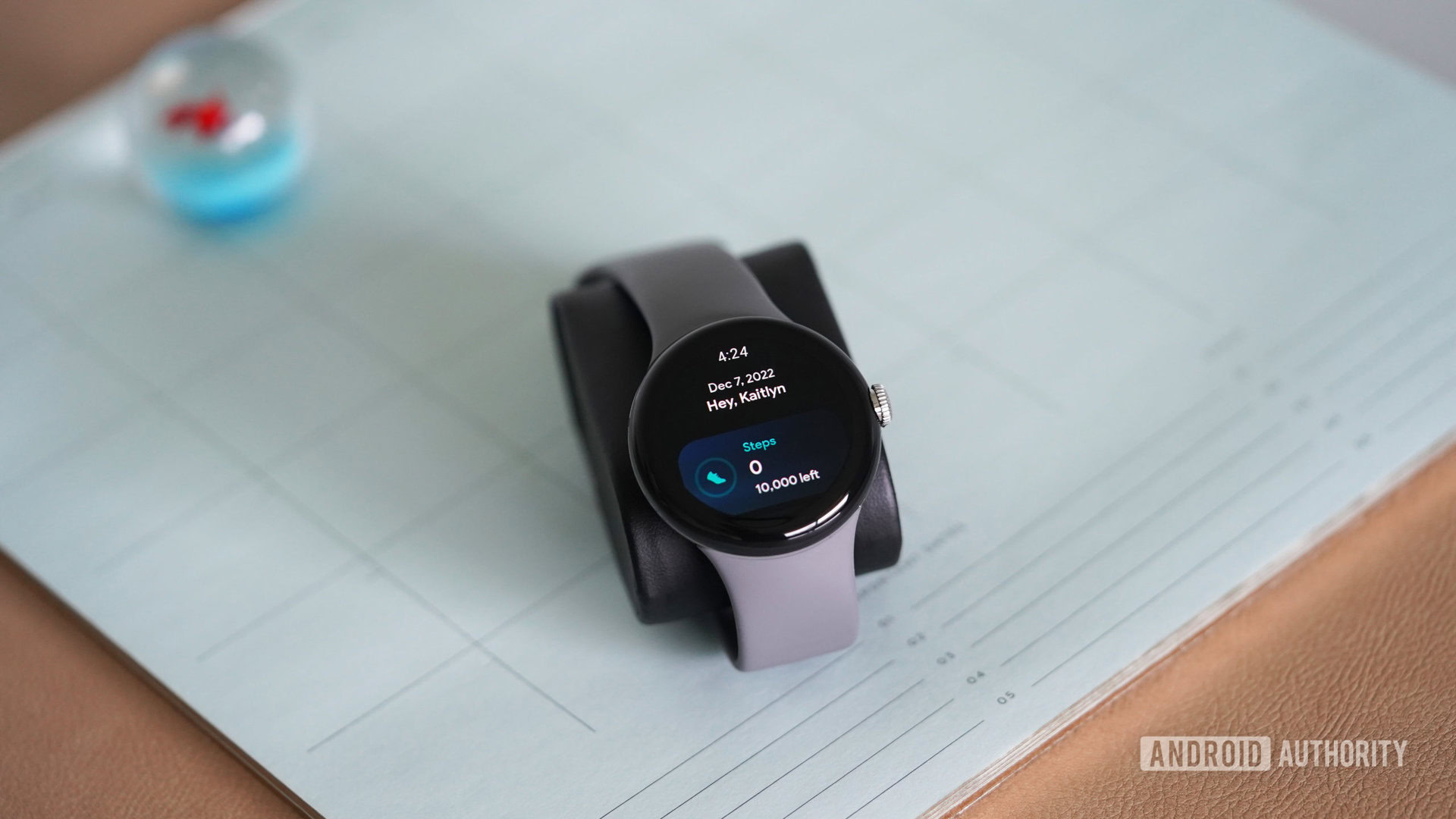 A Google Pixel Watch rests on a desktop calendar.