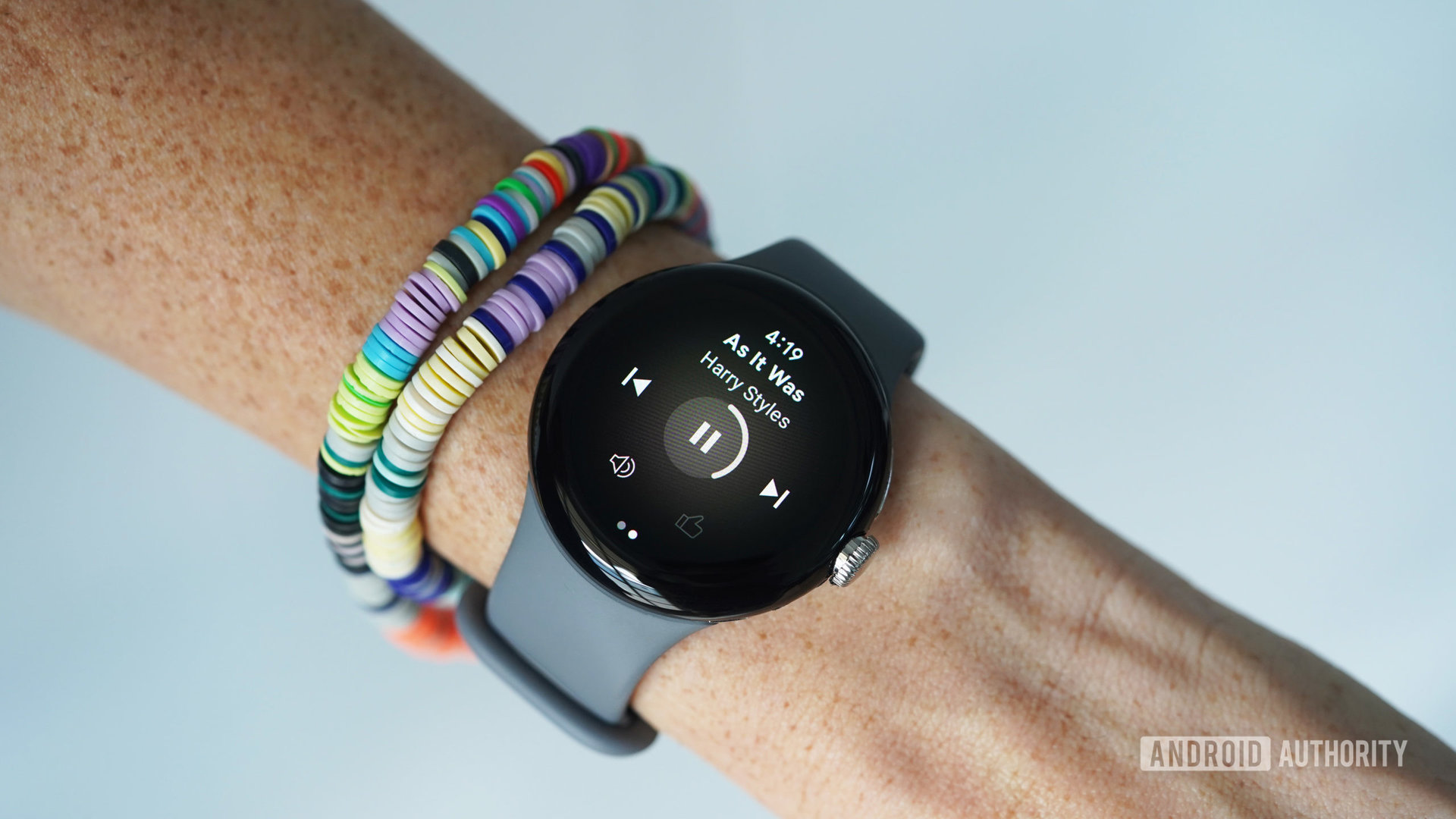 A Google Pixel Watch displays a user's current music selection.
