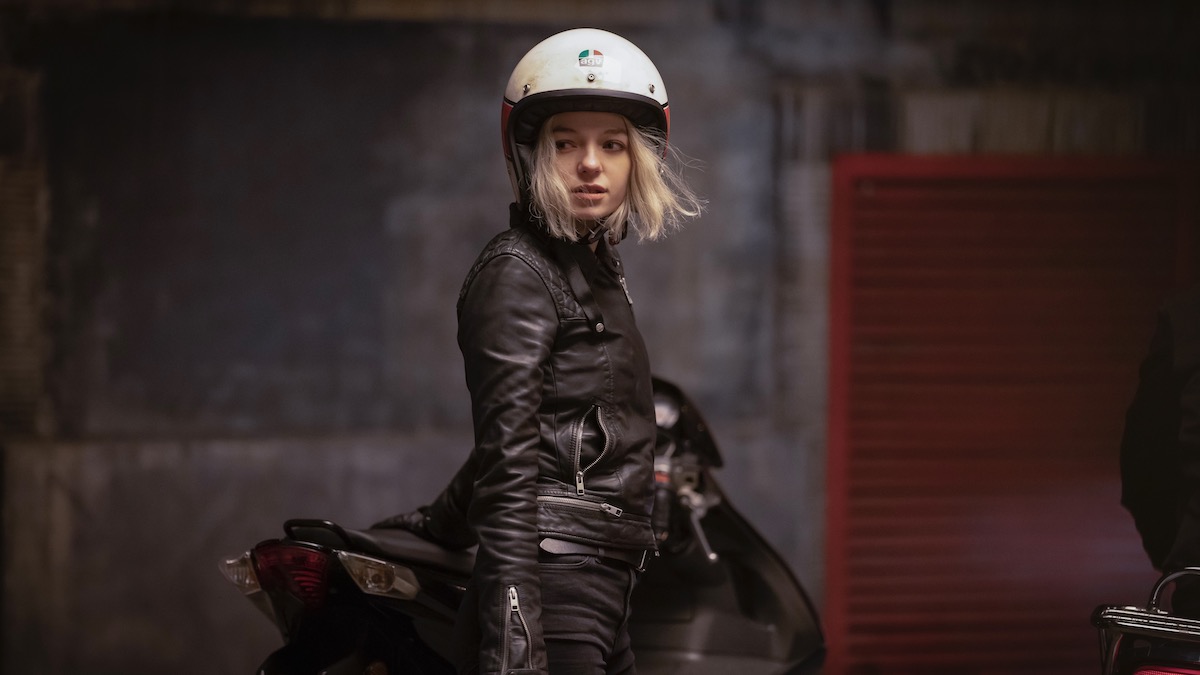 A young woman wears a motorcycle outfit in Hanna best amazon shows