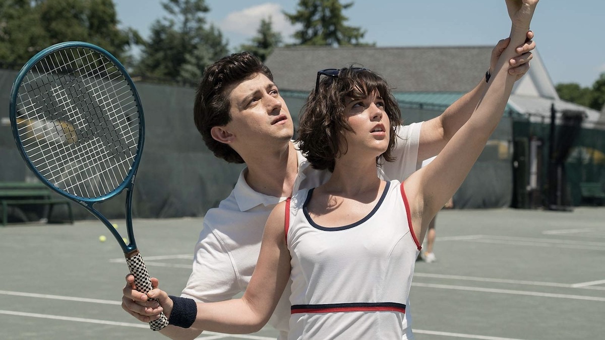 Seorang pria dan wanita muda bermain tenis di Red Oaks