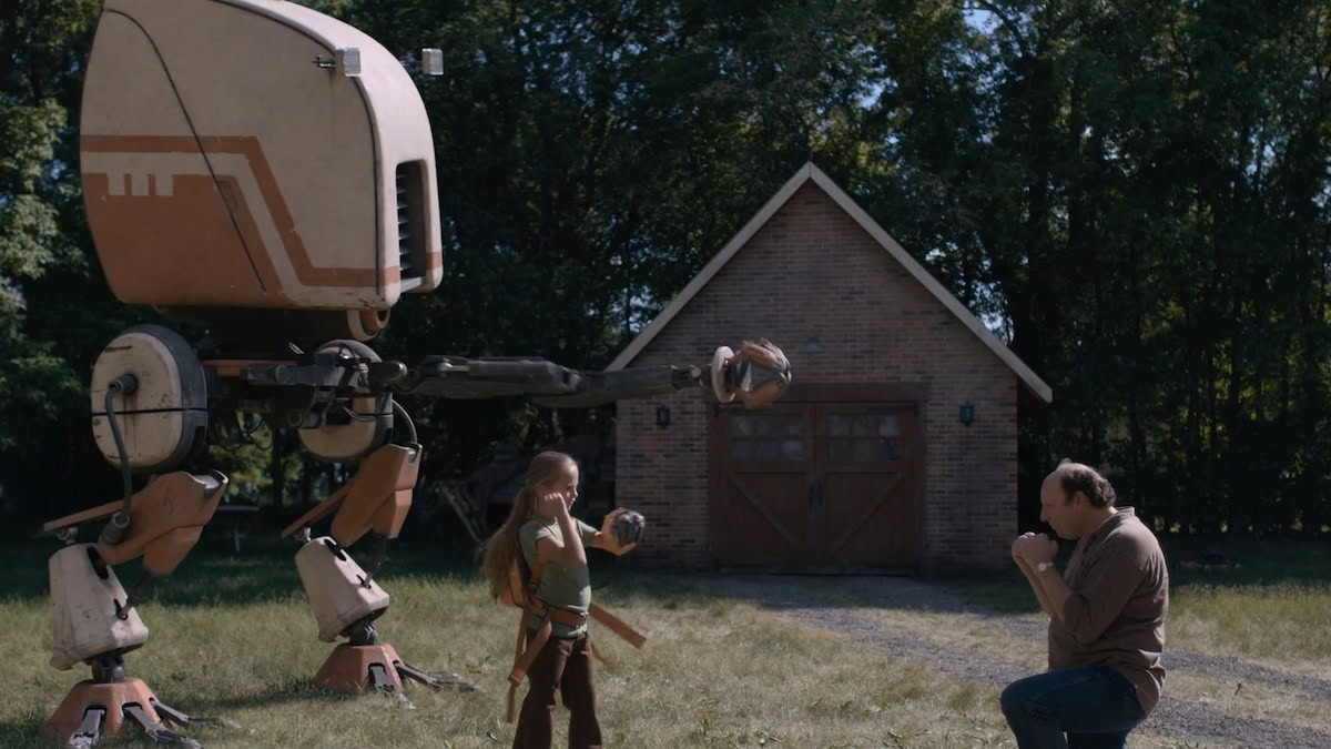 A father and daughter in a field with a robot in Tales from the Loop