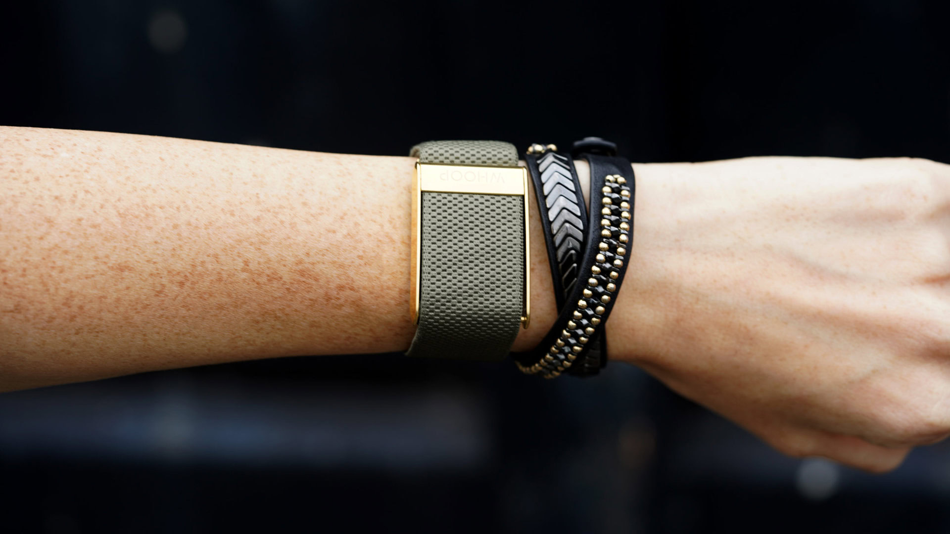 A Whoop 4.0 on a user's wrist utilizes an Ivy with Gold Luxe band.