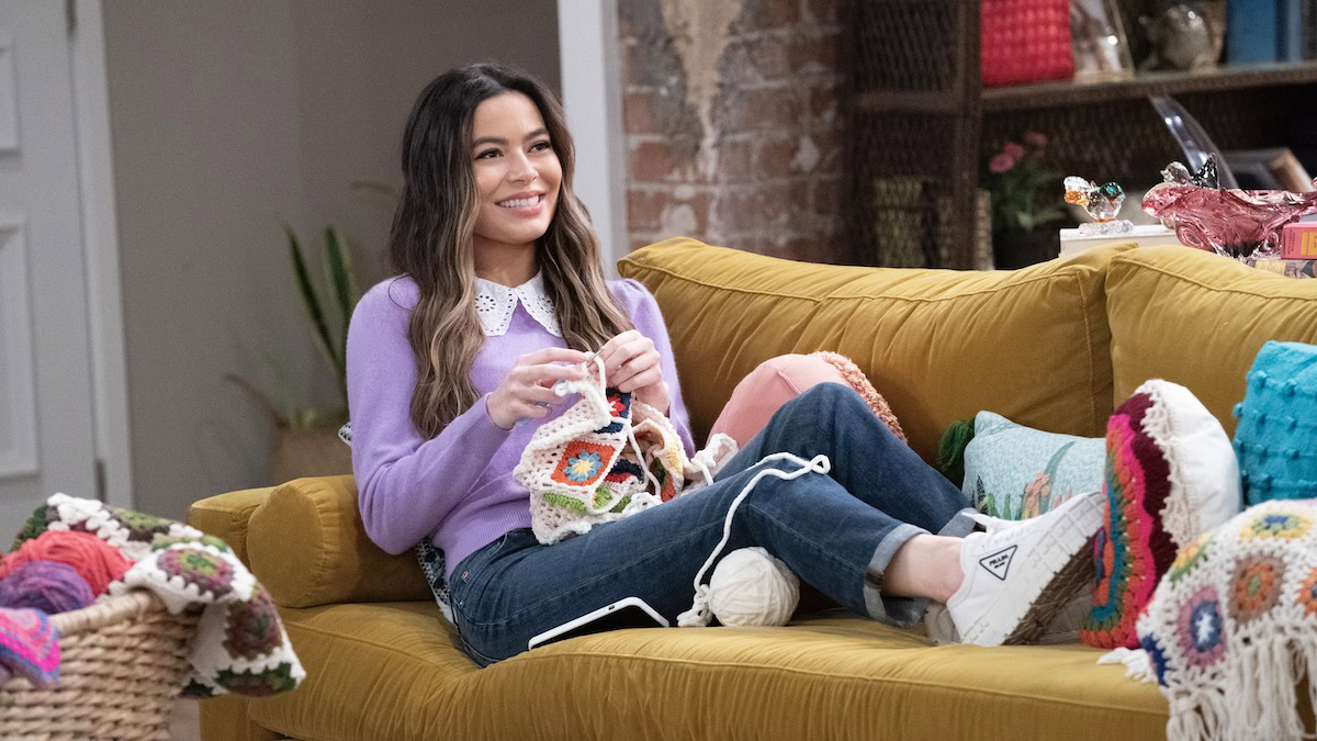 Miranda Cosgrove as Carly Shay knitting on a couch in iCarly