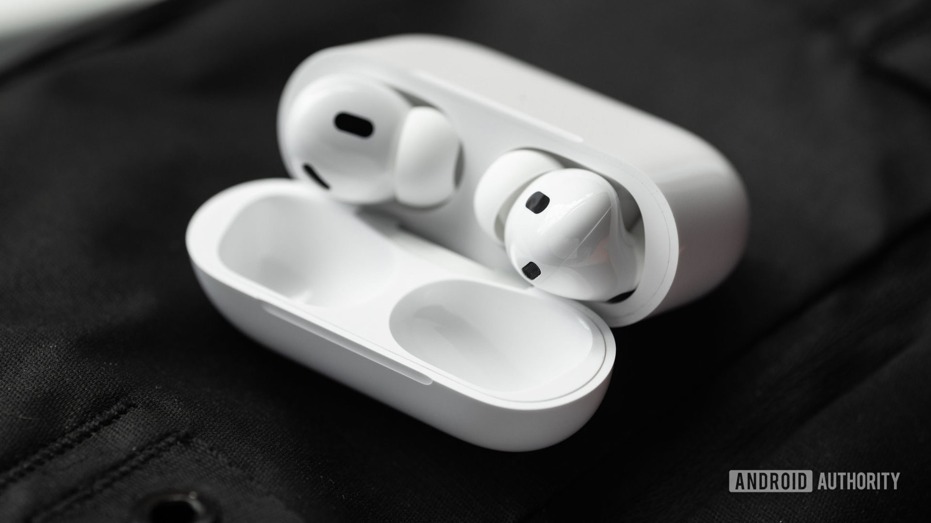 The Apple AirPods Pro (2nd generation) case is open and laying at an angle to show the earbuds and their sensors.