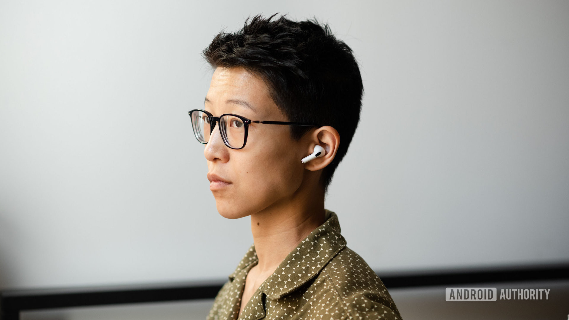 A person wears the Apple AirPods Pro (2nd generation) in three-quarters view.