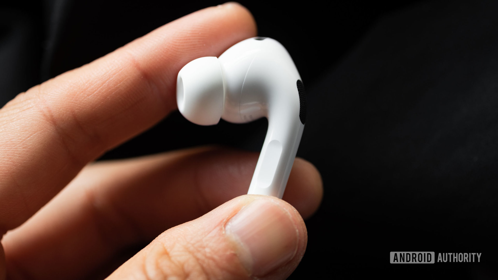 A hand holds the left earbud of the Apple AirPods Pro (2nd generation) to show off the stem.