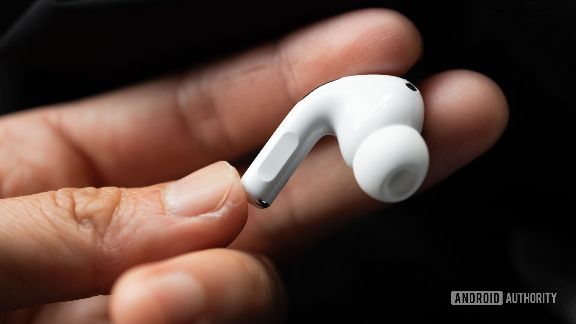 A hand holds the right earbud of the Apple AirPods Pro (2nd generation) to show off the stem.
