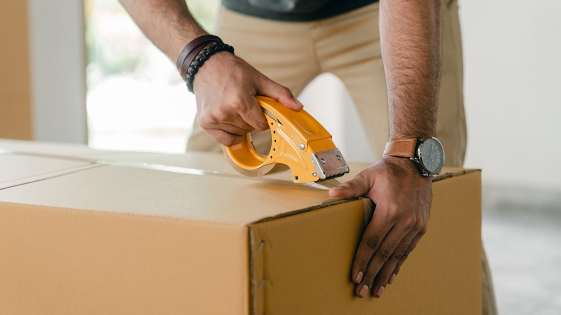 Man Sealing a Package with Tape