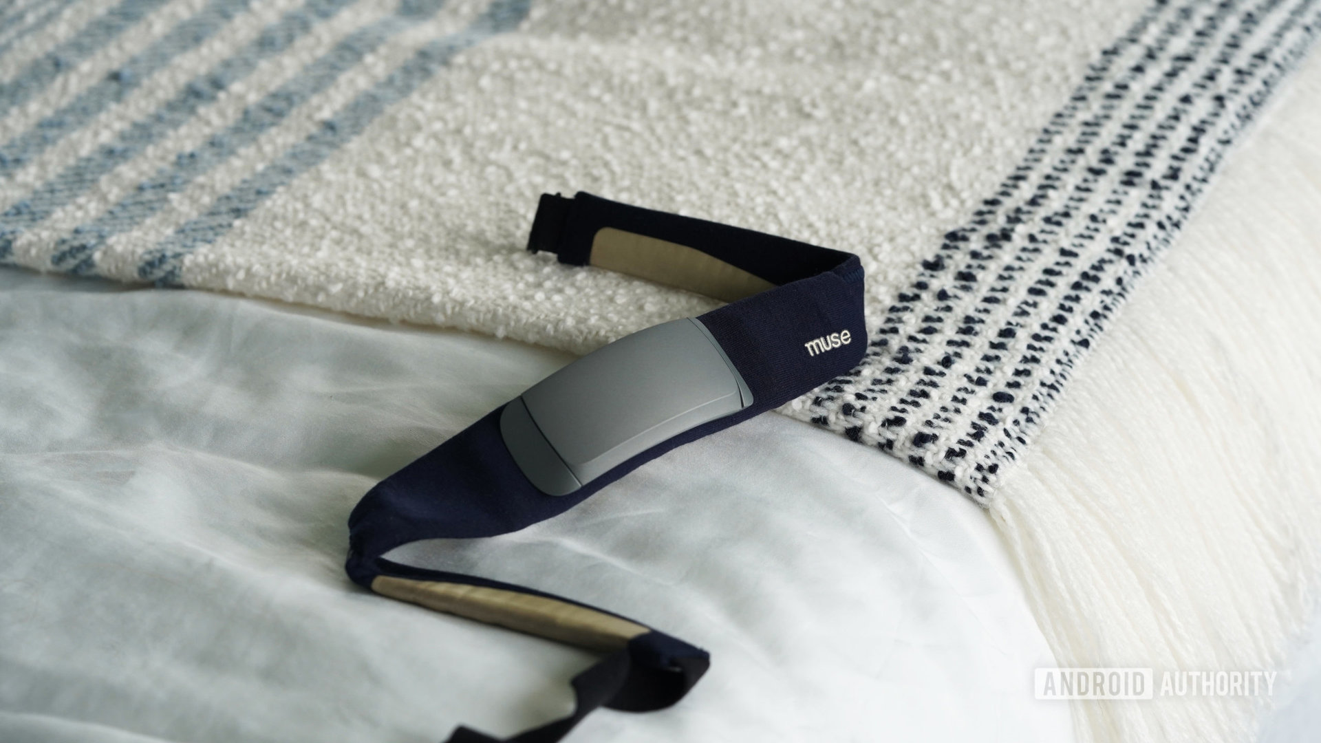 A second-generation Muse S headband rests on a user's bed.