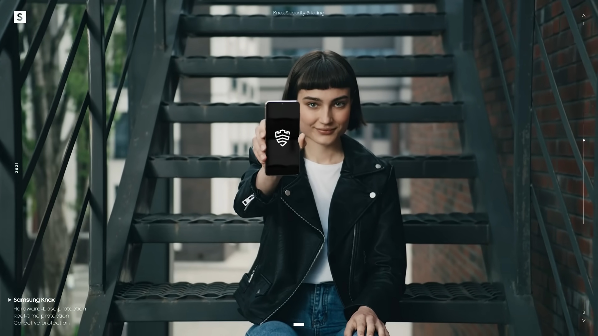 Woman sitting on stairs, holding out a phone that shows the Samsung Knox logo