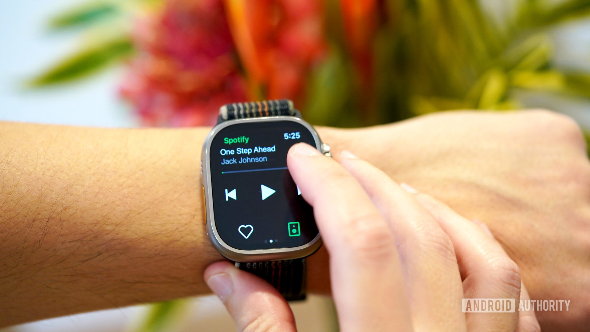 An Apple Watch Ultra user controls music playback in the Spotify app.