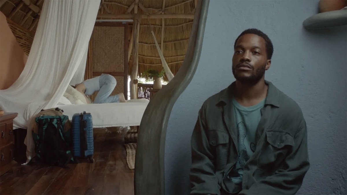A man sits in the foreground with a woman huddled on a bed in the background in The Drop - best new streaming movies