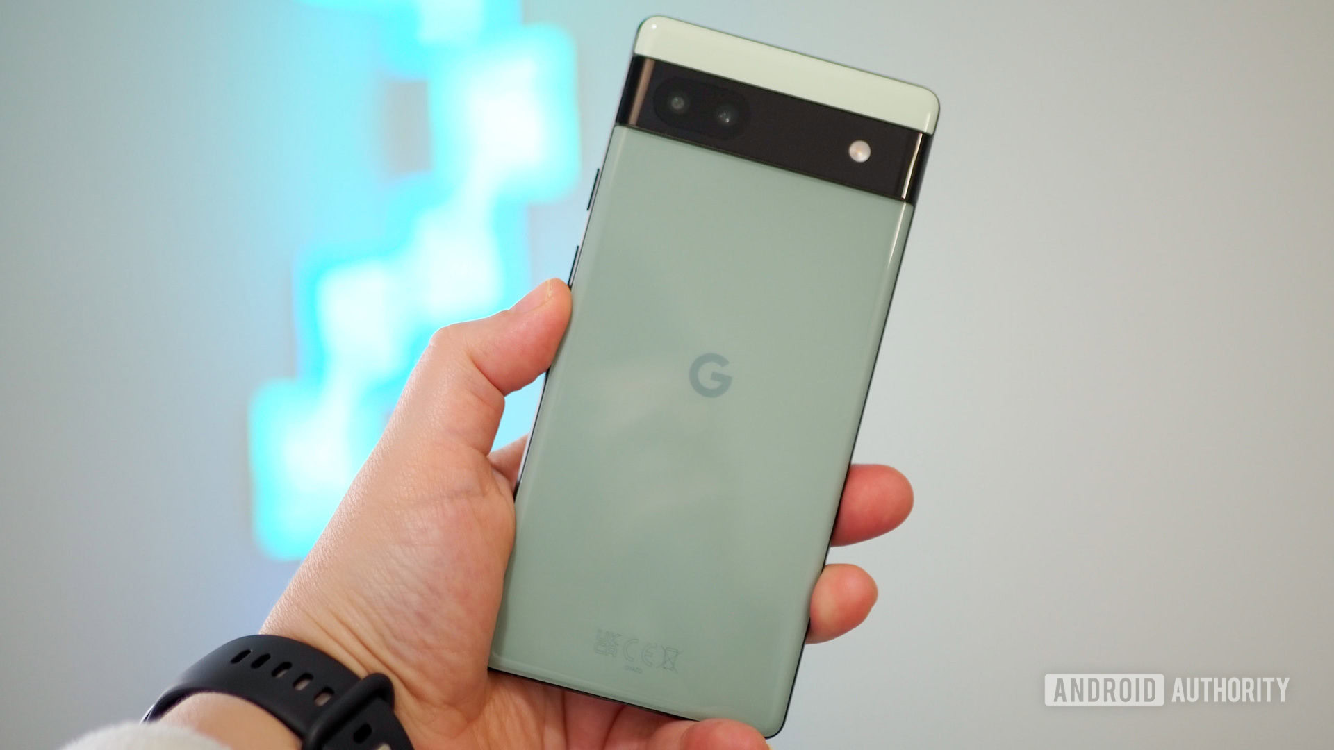 Google Pixel 6a de couleur Sage en main, vu de dos