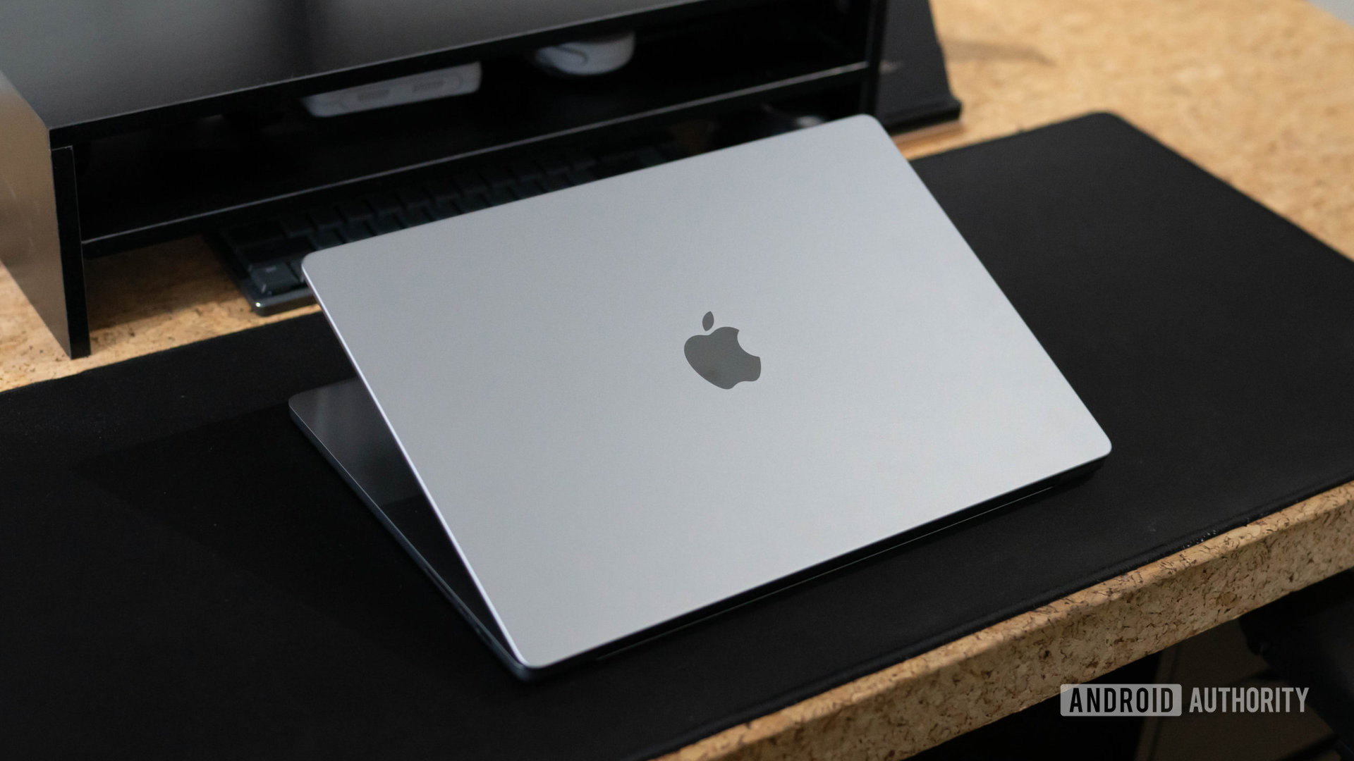 Apple MacBook Pro 2023 lid half open sitting on desk showing Apple logo