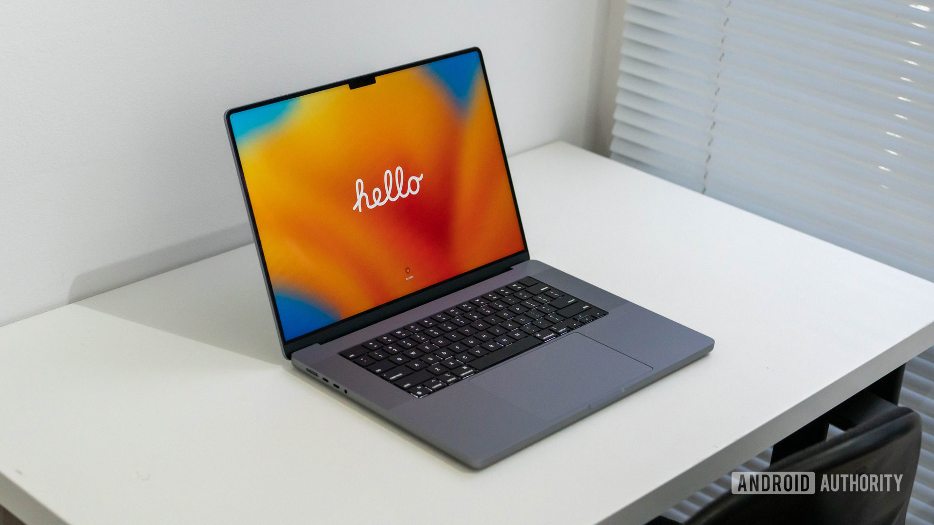 Apple MacBook Pro 2023 showing hello welcome screen sitting on a table