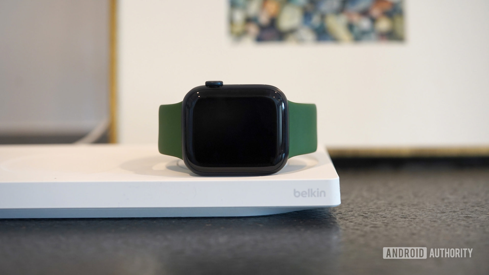 An Apple Watch Series 8 charges on a Belkin BoostCharge Pro 3-in-1 Wireless Charger.