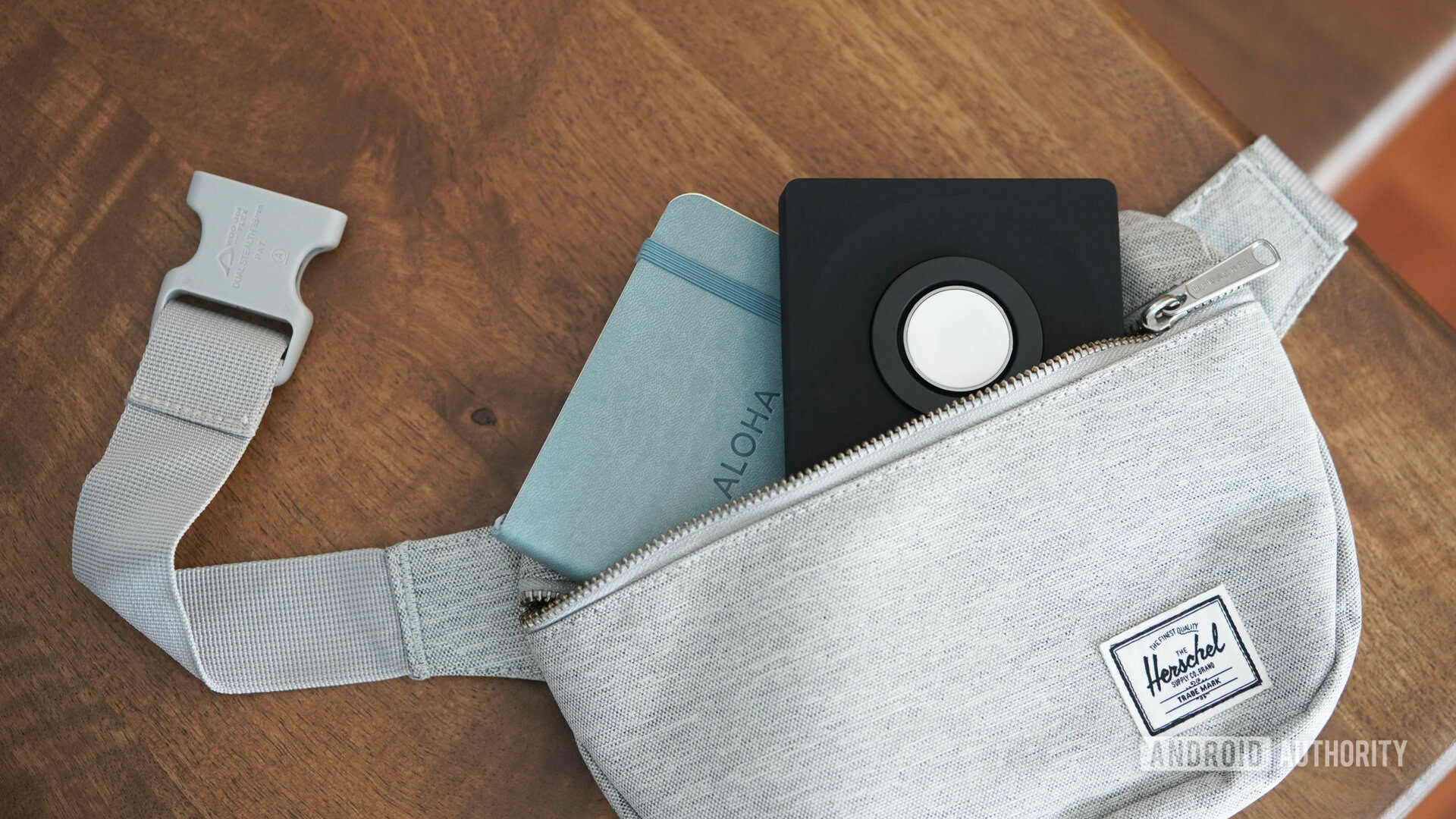 A portable Apple Watch charger pokes out of a fanny pack.