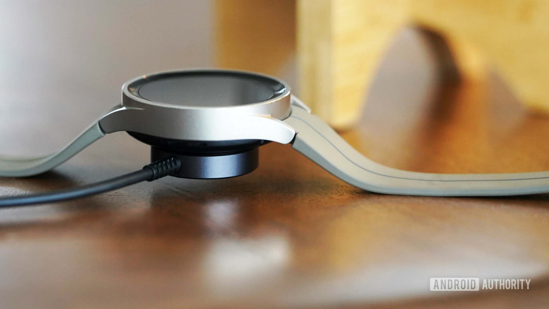 A Samsung Galaxy Watch 5 Pro charges on its magnetic charging puck.
