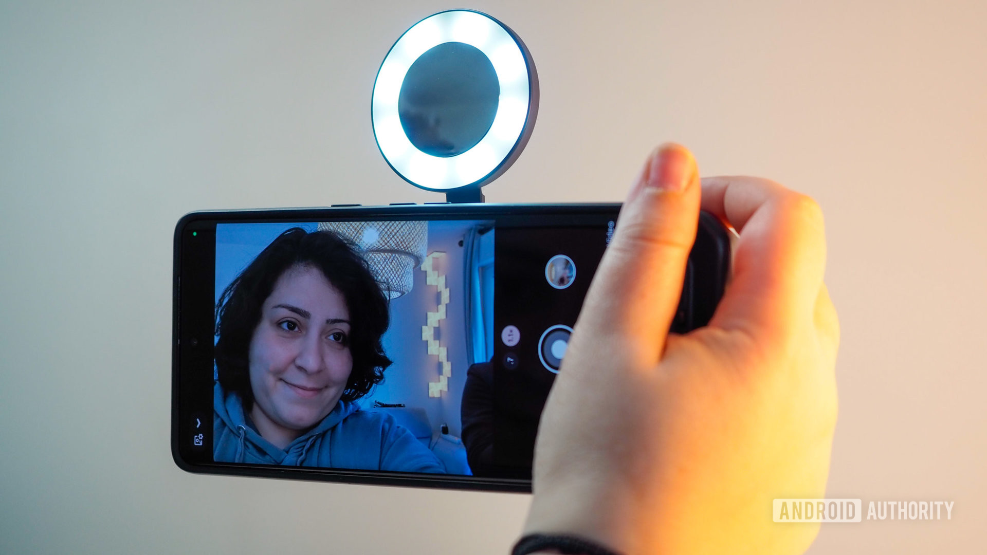 Une femme prenant un selfie sur le Google Pixel 7 Pro en le tenant avec le ShiftCam SnapGrip, avec le SnapLight allumé