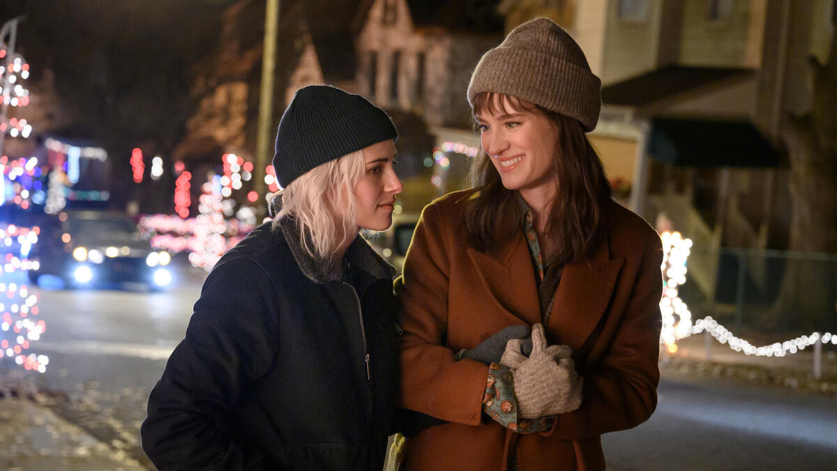 Two women walk arm in arm down the street in winter in Happiest Season - best hulu movies