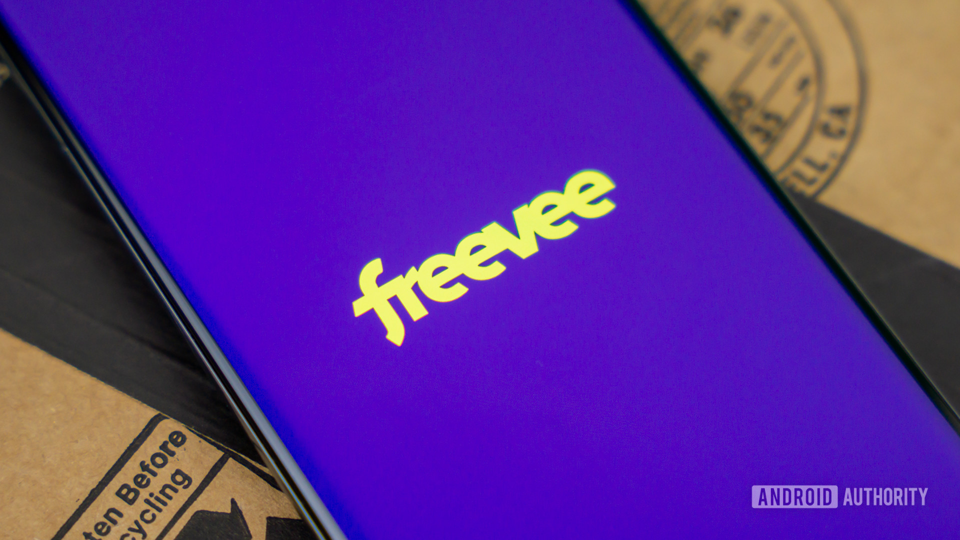 Stock photo of Freevee by Amazon logo on phone next to box 3
